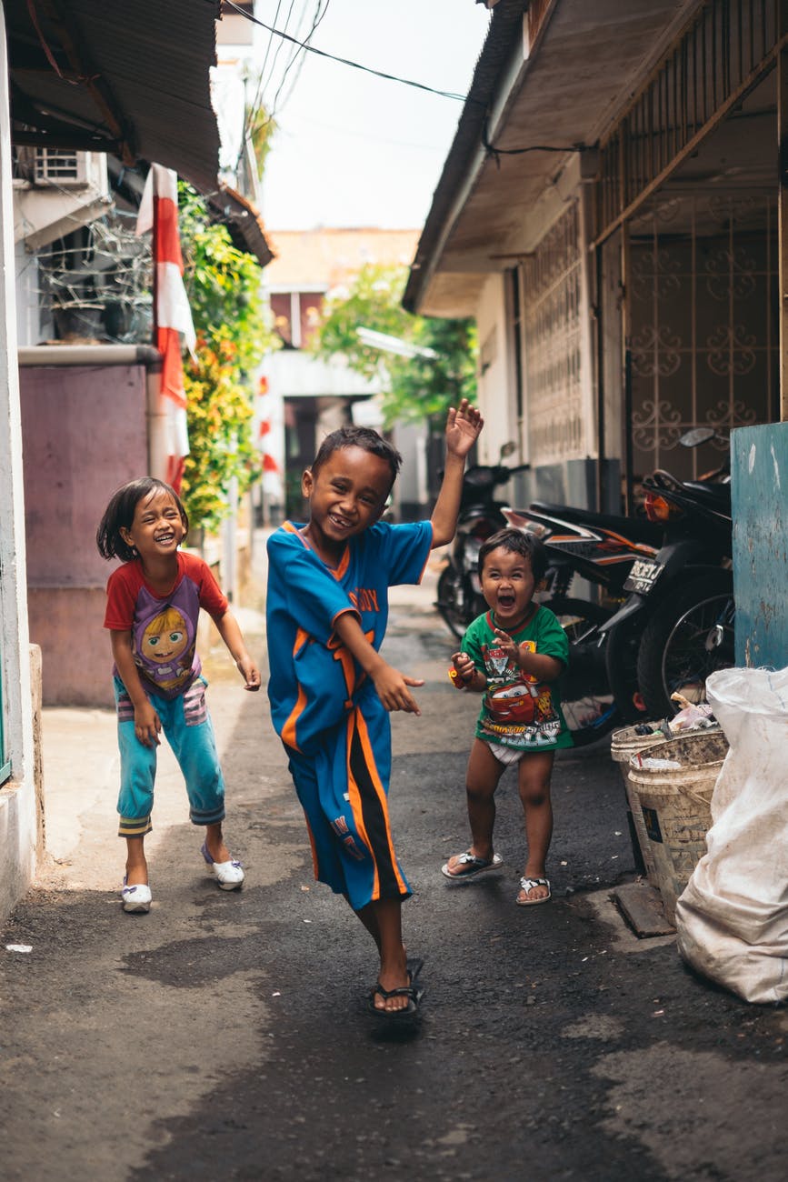 child in blue and yellow jersey shirt with the two other kids