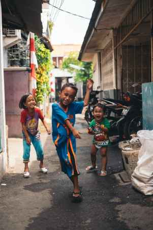 child in blue and yellow jersey shirt with the two other kids